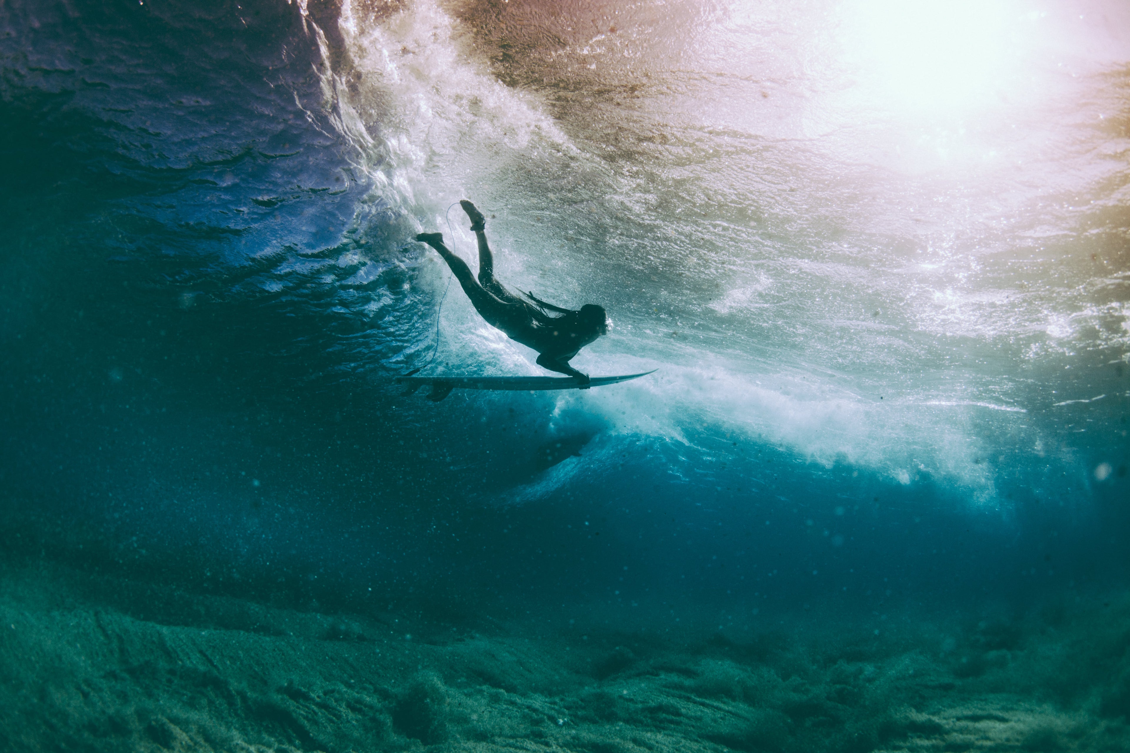 Female surfer beneath the waves